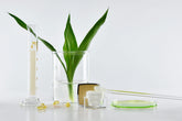 jar of skincare in cosmetic lab with beaker and greenery in background